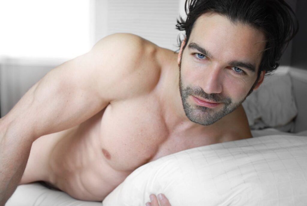 Hombre sexy desnudo en la cama